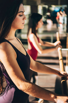Side view of confident serious dancers practicing ballet in sunlight.