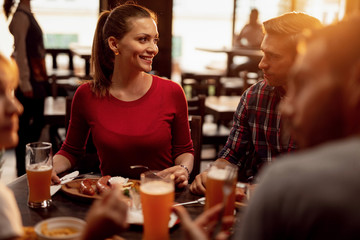 Happy woman enjoying with friends in a lunch at a restaurant.