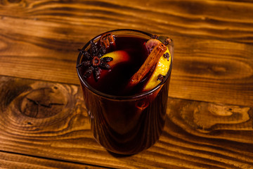 Cup of mulled wine with cinnamon on wooden table