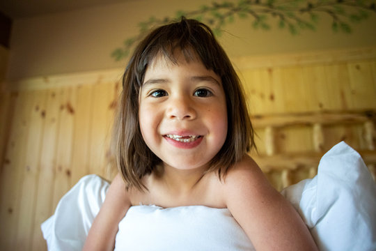 A toddler aged girl waking up from a nap inside of a house.