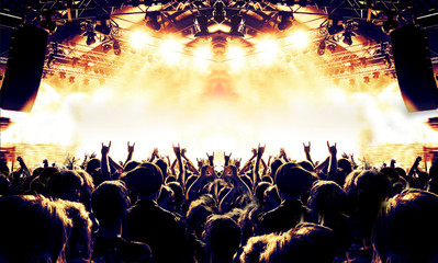 Raised hands in front of a concert stage for a festive crowd