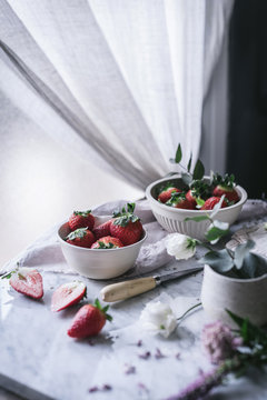 Strawberries and flowers on marble table