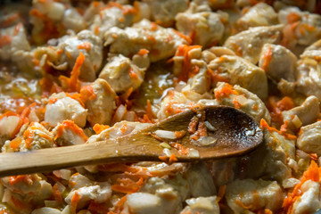 Cooking, sliced carrots and meat fried in a pan