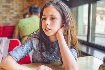 Teenage girl waiting for her order in the cafe