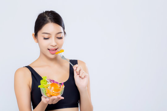 Beautiful portrait young asian woman smiling holding salad vegetable food isolated on white background, girl diet eating vegetarian for healthy, health care or wellness concept.