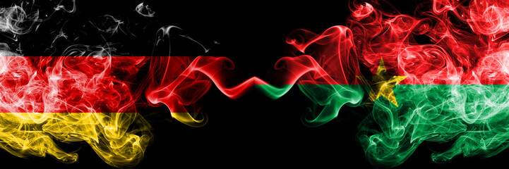 Germany vs Burkina Faso smoky mystic flags placed side by side. Thick colored silky smoke flags of Deutschland and Burkina Faso