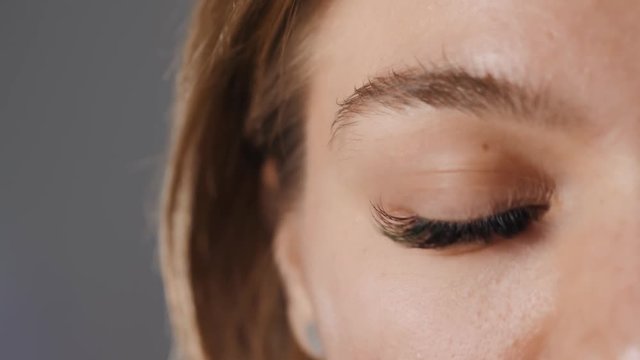 Close up macro view of beautiful green female woman girl student eye with long eyelashes, smooth healthy skin. Eyelash extension procedure. Perfect trendy eyebrows. Good vision, contact lenses. Eye
