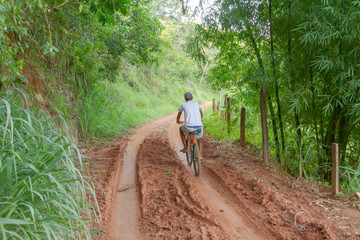 Obraz premium Homem de bicicleta em estrada rural brasileira