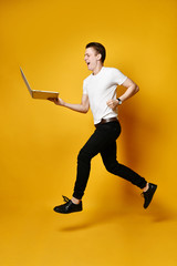 Fototapeta na wymiar Jumping student with laptop