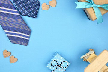 Fathers Day frame of gifts, ties and hearts on a blue background. Top view with copy space,