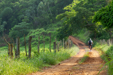 Obraz premium Homem de bicicleta em estrada rural brasileira