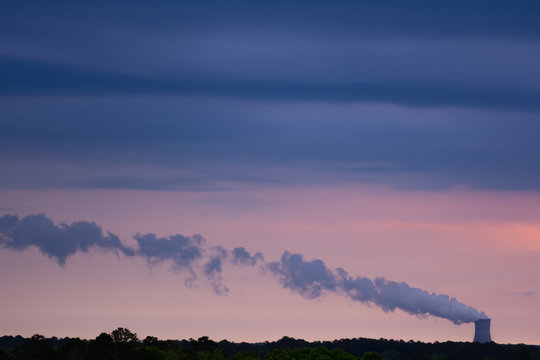 Sunrise view of a nuclear power plant cooling tower and its steam plume near Raleigh, North Carolina