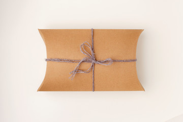 Gift box from craft paper and tied sack rope top view isolated on white background
