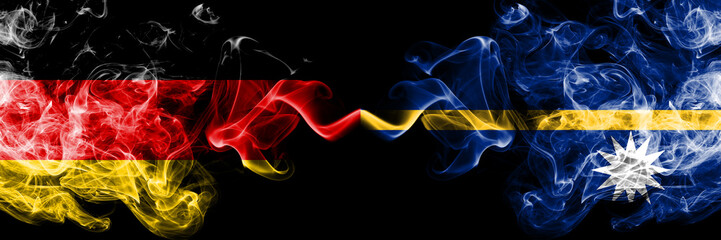 Germany vs Nauru smoky mystic flags placed side by side. Thick colored silky smoke flags of Deutschland and Nauru