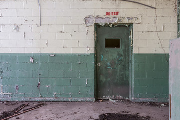 Decaying green door in abandoned factory