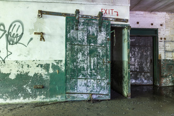 Giant green metal door on sliding rail in abandoned factory