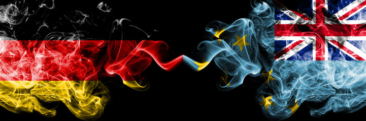 Germany vs Tuvalu, Tuvaluan smoky mystic flags placed side by side. Thick colored silky smoke flags of Deutschland and Tuvalu, Tuvaluan