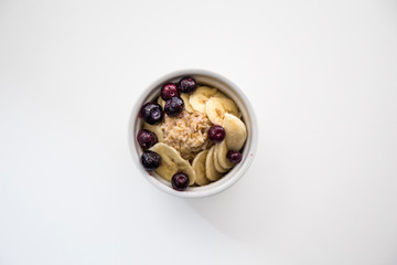 Bowl of homemade oatmeal porridge with banana, blueberries