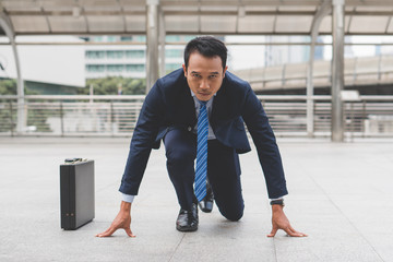 Businessman set in start running position prepare to fight in business race.