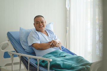 Smiled asian elderly man on the bed in the hospital