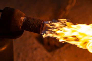 Close-up male welder welds metal using a gas burner.  Worker use gas burner for metal parts in a...
