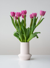 Pink spring tulip flowers in ceramic vase