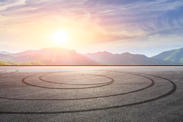 Fotobehang Formule 1 Empty asphalt race track and beautiful natural landscape at sunset  © ABCDstock