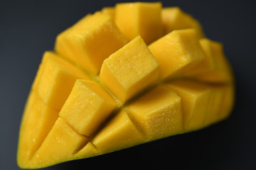 Mango slice with cubes on dark background