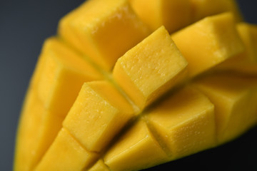 Mango slice with cubes on dark background - Close-up