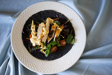 Black charcoal wrap with vegetables and chicken schnitzel