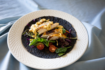 Black charcoal wrap with vegetables and chicken schnitzel