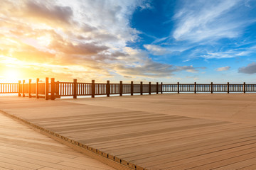 Lakeside wood floor platform and sky clouds at sunset