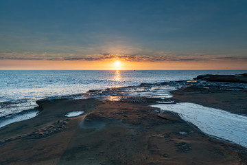 Rock Platform Sunrise Seascape with Light Smattering of Clouds