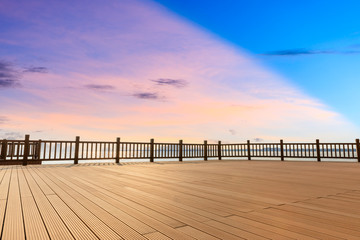 Lakeside wood floor platform and sky clouds at sunset