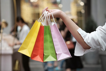 Young woman holding sale shopping bags. consumerism lifestyle concept in the shopping mall