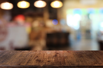 Empty dark wooden table in front of abstract blurred bokeh background of restaurant . can be used for display or montage your products.Mock up for space.