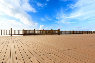 Lakeside wood floor platform and blue sky with white clouds