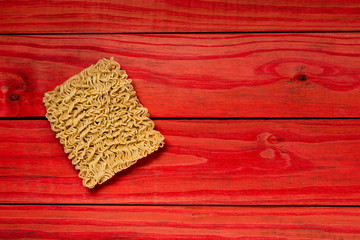 Quick cooking noodle is one on a red background with copy space