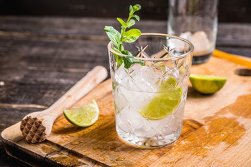 Old fashioned beverage with lime and mint leaves. Selective focus. Shallow depth of field.