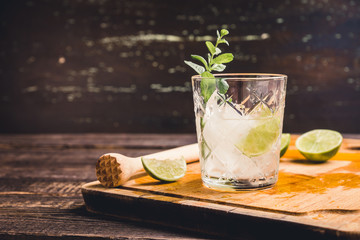 Old fashioned beverage with lime and mint leaves. Selective focus. Shallow depth of field.