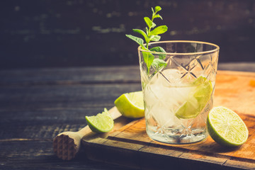 Old fashioned beverage with lime and mint leaves. Selective focus. Shallow depth of field.