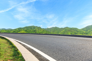 Country road and green mountains natural landscape under the blue sky