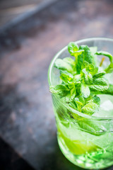 Summer old fashioned beverage with melon liqueur and mint leaves. Selective focus. Shallow depth of field.