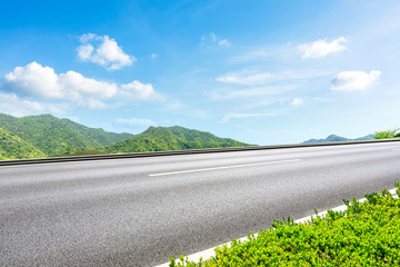 Country road and green mountains natural landscape under the blue sky