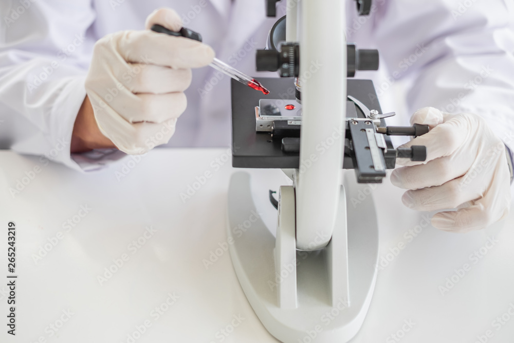 Wall mural a scientist hands working in laboratory with test tube microscope and solutions.