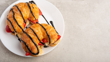 Breakfast with croissant, bananas and strawberries. with chocolate, with space