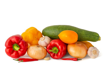Vegetable set of bright ripe appetizing fruit peppers onion zucchini and garlic pink tomato and hot chili peppers on a white background