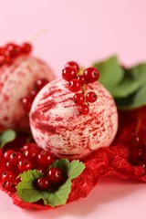 bath bomb with berries extract.red  bomb for a bath set and red currant berries on a pink background. Organic berry body cosmetics