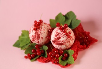 bath bomb with berries extract.red striped bomb for a bath set and red currant berries on a pink...