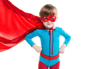 Boy dreamer in a superhero costume, blue bodysuit and red cloak.